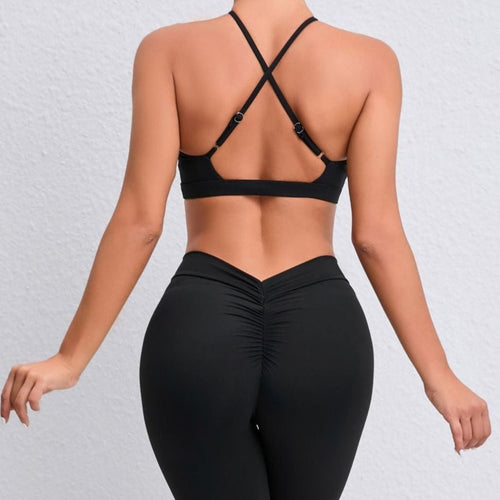 Person wearing a black sports bra and leggings on a light gray background