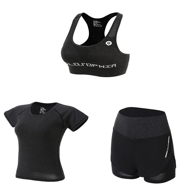 Black athletic outfit with sports bra, t-shirt, and shorts on a white background